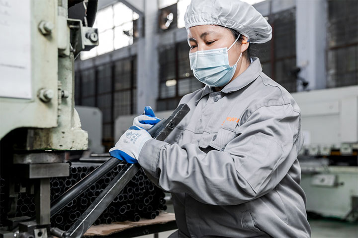 a female worker is molding metal bars